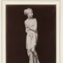 Venus Italica standing marble statue with draped cloth, turned to the right on a round pedestal.