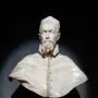 White marble bust of Pope Innocent X on a pedestal against a dark background.