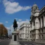 Duke of Cambridge equestrian statue on a stone pedestal in front of a classical building with columns.