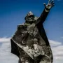 Kościuszkowców Memorial with a skateboarder performing a trick beside the bronze monument
