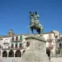 Francisco Pizarro equestrian statue on a stone pedestal in a sunlit square.