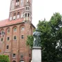 Nicolaus Copernicus Monument in Toruń, a bronze robed figure pointing upward with a celestial sphere in hand.