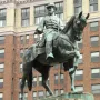 General James B. McPherson equestrian statue in bronze with a green patina, shown against a tall brick building.