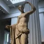 Townley Venus marble statue with one arm raised and draped fabric over the lower body.