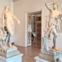Orfeo y Eurídice marble statues facing each other in a museum room, with Eurydice reaching out and Orpheus holding a hand to his brow.