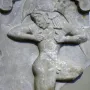 Ancient Greek relief showing a forward-leaning male runner in profile with bent arms.