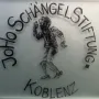 Frosted Schängel Stiftung sign in Koblenz with a boy etching and raised hand