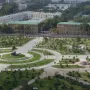 Timur equestrian statue on a pedestal in a landscaped park with lawns, trees, and paths.