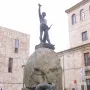 Monument to Viriato, a dark metal warrior sculpture on a large boulder behind an iron fence.