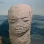 Škloŭ Idol, a weathered stone sculpture with a stylized human-like face.