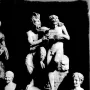 Pan and Daphne marble sculpture showing a bearded, horned figure embracing a nude youth holding a small musical instrument.