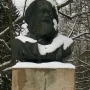 Karl Marx bust on a tall concrete pedestal in a snowy outdoor setting.
