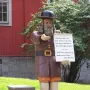 Rosenbom, a life-size wooden figure of a bearded man in historical clothing, holding out one hand and a scroll.