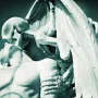 The Kiss of Death sculpture showing a skeletal figure leaning over a bare-chested man with its face pressed to his forehead.
