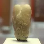 Ain Sakhri Lovers stone sculpture with two rounded lobes on a dark base.