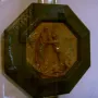Creation of Eve terracotta relief showing two figures embracing within a dark octagonal frame.