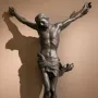 Bernini\'s Corpus, a dark bronze crucified Christ with outstretched arms, bowed head, and crown of thorns.