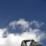 Dark bronze equestrian statue of Francisco Franco against a blue sky with scattered clouds.