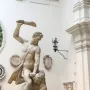 Samson Slaying a Philistine marble sculpture in a museum gallery, with one figure standing over another and raising a club.