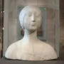 Pale marble bust of a young woman wearing a close-fitting headpiece