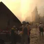 Cloud Fortress stands at the left amid rubble, with recovery workers in hard hats and reflective vests in the foreground.