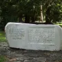 Keys Handover Memorial stone monument with a relief of historical figures and Cyrillic inscription