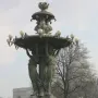Bartholdi Fountain in a snowy park with a domed building visible through bare trees