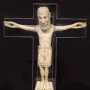 Carrizo Christ carved ivory figure with outstretched arms on a dark cross-shaped background