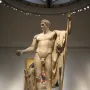 Napoleon as Mars the Peacemaker statue of a muscular male figure holding an orb and staff in a museum