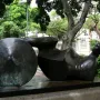 Goslar Warrior, a dark bronze reclining abstract sculpture with a circular disc on a rectangular base outdoors.