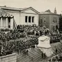 Charles Devens equestrian statue on a tall pedestal, surrounded by a large crowd during a public ceremony.
