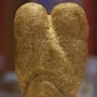 Ain Sakhri Lovers stone sculpture with two rounded lobes on a dark base.
