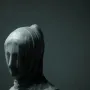 The Veiled Nun sculpture showing a veiled marble bust with the face softly visible beneath draped fabric.
