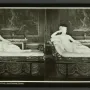 Reclining white marble statue of Venus Victrix on an ornate chaise lounge in a gallery room