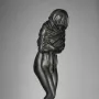 Winter, a dark bronze female figurine wrapped in heavy drapery and standing on a circular base.