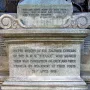 Inscribed stone base of the Titanic Engineers\' Memorial with dedication text and a biblical verse.
