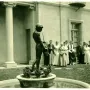 The Spirit of Spanish Music sculpture shows a dark male figure wearing a head wreath and playing a long flute in a fountain basin.