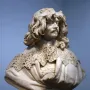 Marble bust of Thomas Baker with long wavy hair, a mustache, and an ornate lace collar.