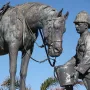 Close-up of the Horse Memorial showing a uniformed soldier in a pith helmet offering a bucket to a saddled horse.