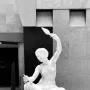 Jeune fille de Mégare, a white marble sculpture of a seated young woman holding a spindle and distaff