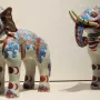 Pair of Kakiemon porcelain elephant figurines decorated in white, blue, red, and gold with yellow tusks.