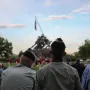 Marine Corps War Memorial with spectators seated in the foreground and the bronze flag-raising sculpture in the background.
