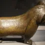 The Lion of Monzon sculpture shown from a three-quarters angle, with engraved decorative patterns across its body.