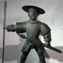 Old Thomas statue of a man in armor with a wide-brimmed hat, mustache, spear, and sword