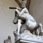 Heracles and Nessus, a white marble sculpture of a muscular man raising a club over a struggling centaur.