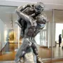 I Am Beautiful, a bronze sculpture showing a muscular male figure carrying a smaller figure on his back and shoulders.