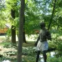 Morianbron sculpture standing on a boulder beside a stream with a rope and wooden walkway nearby