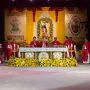 Black Nazarene statue in red and gold robes carrying a cross beneath a floral archway