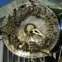Close-up of the Hornsby Water Clock face with brass hands, bronze letters, and decorative animal figures around the rim.