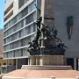 Monumento a Júlio de Castilhos with a tall stone obelisk on a multi-tiered base and bronze figures around it.